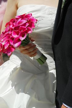 Bride and groom. Closeup on wedding bouquet.