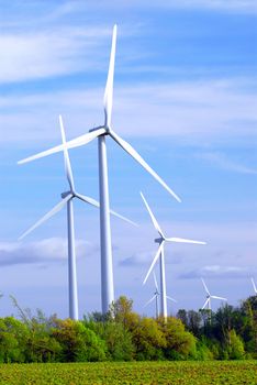 Wind power generators in the field against blue sky