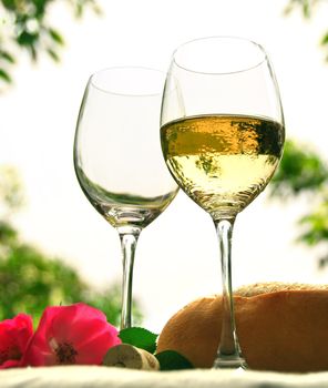 Two wineglasses with white wine on the table outside