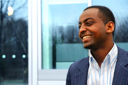 Portrait of a young attractive businessman next to a corporate building