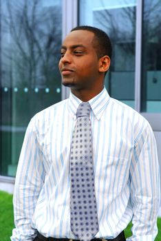 Portrait of a young handsome businessman next to a corporate building