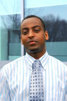 Portrait of a young attractive businessman next to a corporate building