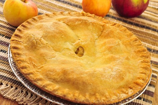 Whole apple pie with apples close up