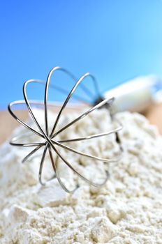 Flour and whisk on kitchen board close up