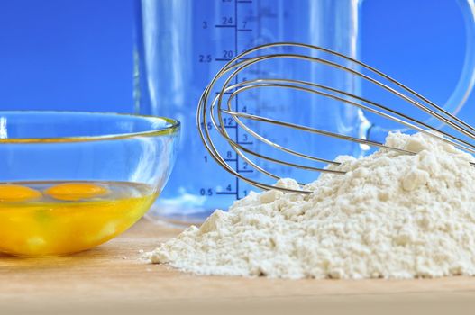Flour, whisk and eggs in a bowl, baking ingredients