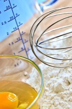 Flour, whisk and eggs in a bowl, baking ingredients