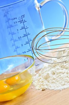 Flour, whisk and eggs in a bowl, baking ingredients