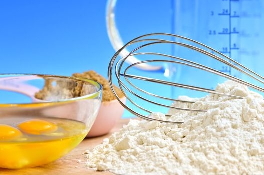 Flour, whisk and eggs in a bowl, baking ingredients