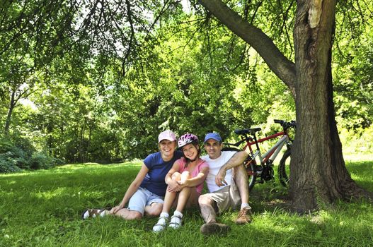 Family resting in summer park with bicycles