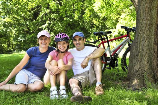 Family resting in summer park with bicycles