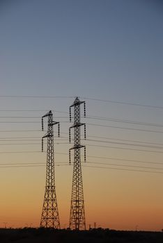 Electrical towers and wires on sunset background 