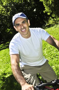 Happy middle aged man riding a bicycle in summer part