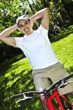 Happy middle aged man riding a bicycle in summer part