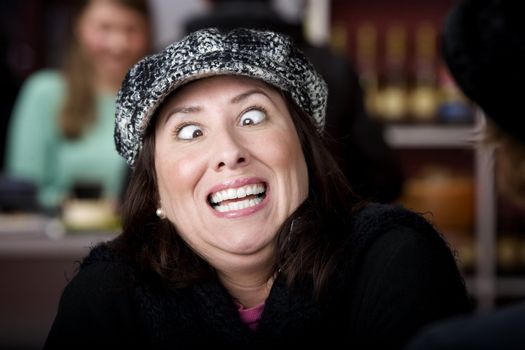 Hispanic woman in hat crossing her eyes