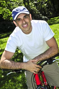 Happy middle aged man riding a bicycle in summer part