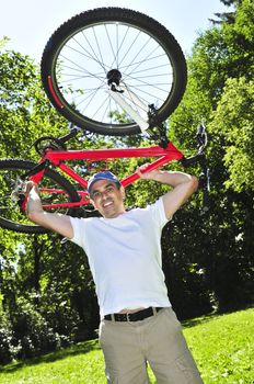 Happy middle aged man with his bicycle in summer part