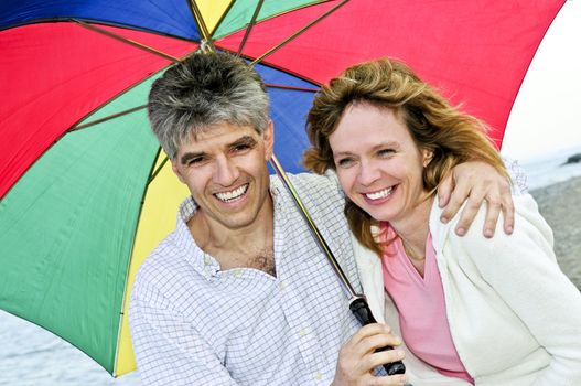 Portrait of happy mature couple under umbrella