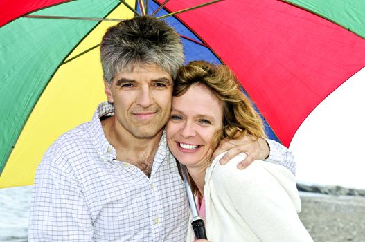 Portrait of happy mature couple under umbrella