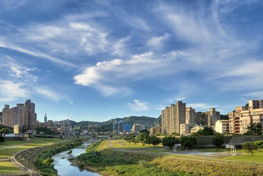 City scenery of park and river under blue sky and white clouds in Taipei, Taiwan.
