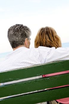 Mature romantic couple on a bench on seashore