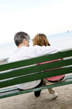 Mature romantic couple on a bench on seashore
