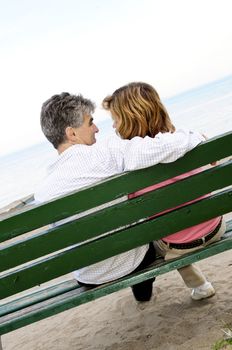 Mature romantic couple on a bench on seashore