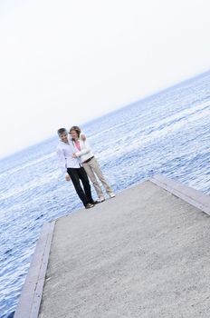 Mature romantic baby boomer couple enjoying seashore