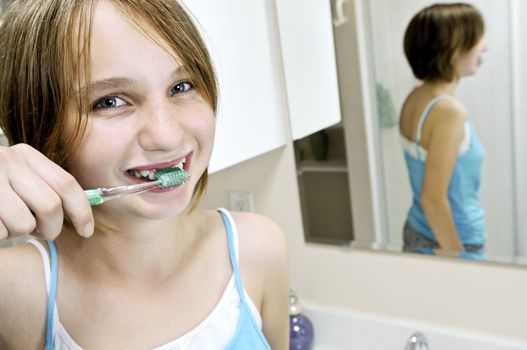 Young girl brushing her teeth in a bathroom