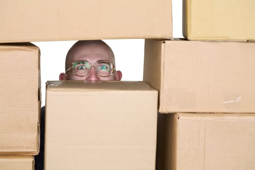 Man looking through window in pile of cardboard boxes