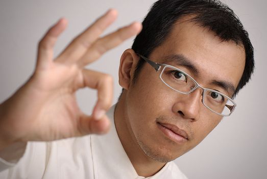 Manager give you a Ok gesture, closeup portrait of Asian business man.