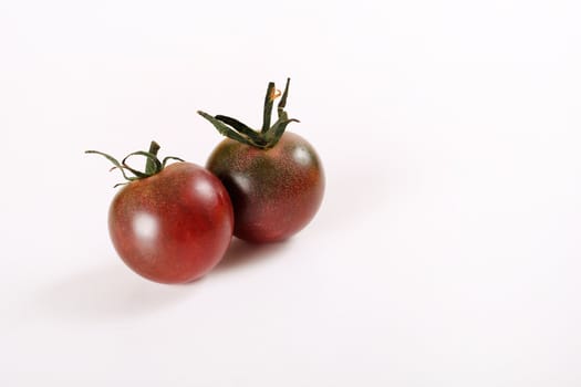 shot of tiny heirloom deep purple cherry tomatoes