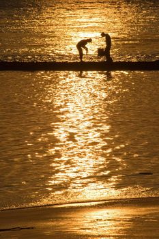 Two boys fishing in the latest golden sunlight