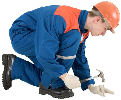 Man in worker overalls with hammer and nail