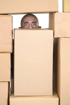 Man looking through window in pile of cardboard boxes