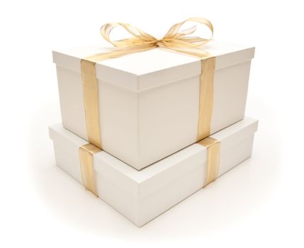 Stacked White Gift Boxes with Gold Ribbon and Bow Isolated on a White Background.