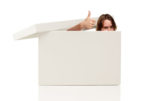 Young Man with Thumbs Up and Popping His Head out from a Blank White Box Isolated on a White Background - Box Ready for Your Own Message.