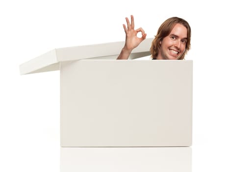 Young Man with Okay Hand Signal and Popping His Head from Blank White Box Isolated on a White Background - Box Ready for Your Own Message.