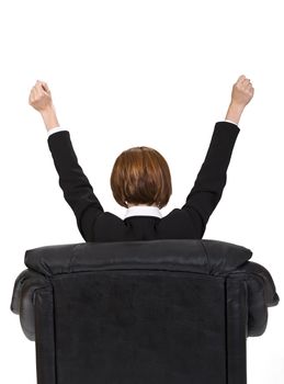 Rear image of a businesswoman sitting in an armchair and expressing satisfaction. 