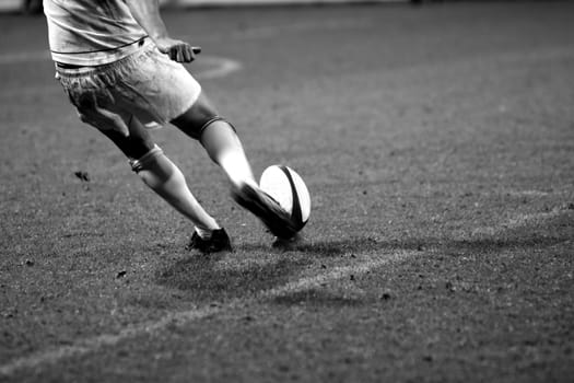 rugby kicker in black and white with motion blur