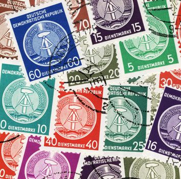 collage of vintage, colorful german postage stamps with GDRs national coat of arms