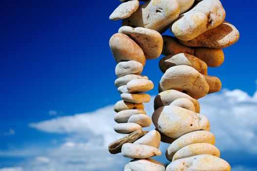 Pile from a sea pebble against the cloudy sky