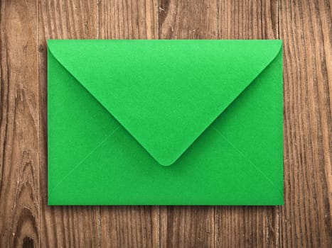green envelope on old wooden table, with clipping path.
