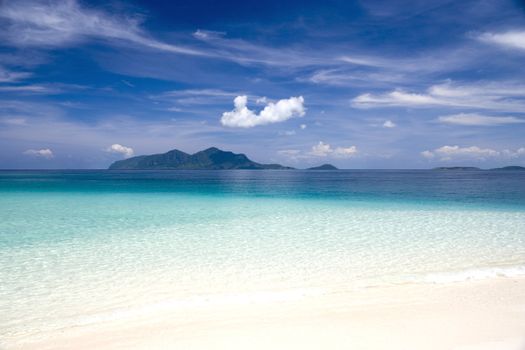 Image of a remote Malaysian tropical island with deep blue skies and crystal clear waters.