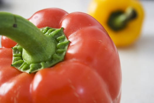 A red and a yellow pepper on Mable Background