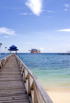 Image of a jetty against a backdrop of a beautiful sea, sky and an oil rig in Malaysia.