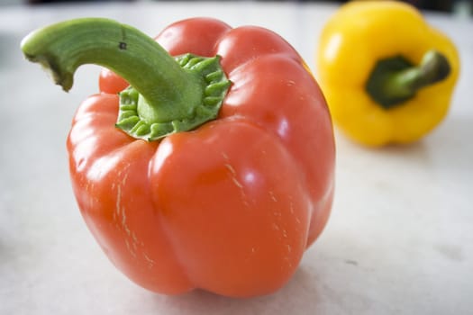 A red and a yellow pepper on Mable Background