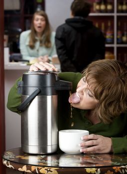 Woman drinking coffee directly from a beverage dispenser