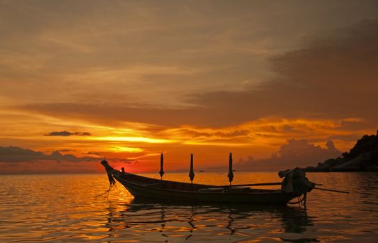 Longtail Boat as the sun sets over the tropical island of Koa Toa in Thailand