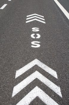 SOS sign with direction arrows on an emergency lane of a freeway