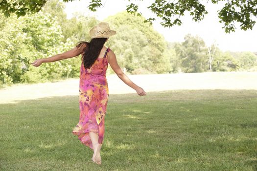 young attractive woman walking away from camera with arms outstretched  